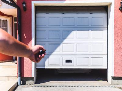 A white, paneled garage door with small, square windows along the top