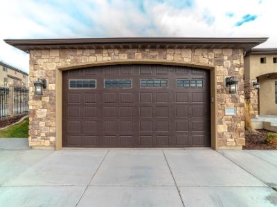 A white, paneled garage door with small, square windows along the top